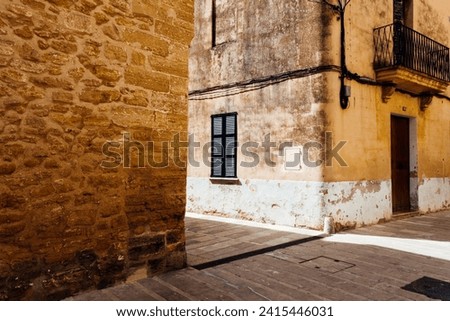 Old street of Alcúdia in Mallorca, Balearic Islands. Old street and old Spanish ochre facades. Old city of Spain. Historic city. buildings Royalty-Free Stock Photo #2415446031