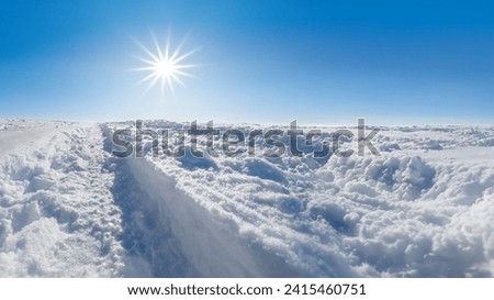 Winter landscape with snow, blue sky and sun star