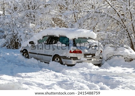 Abandoned car covered with snow on sunny day