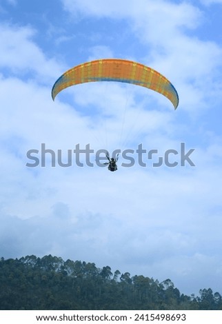 Paragliders fly high above the hills
