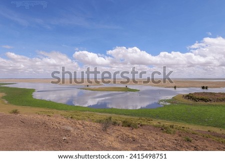clouds are reflected in a lake in the breathtaking landscape of Amboseli NP
