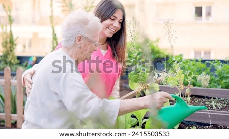 Smiling nurse and senior woman watering plants in a geriatric Royalty-Free Stock Photo #2415503533