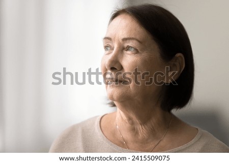 Serious pensive senior woman close up casual portrait with copy space. Thoughtful face of elderly female model looking at window away, daydreaming, thinking, pondering Royalty-Free Stock Photo #2415509075