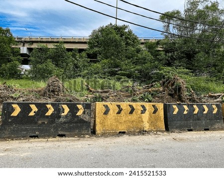 A yellow and black barricade on the side of a road