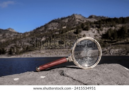 Investigation Concept Magnify Glass Loupe on the Volcanic Rock near a lake