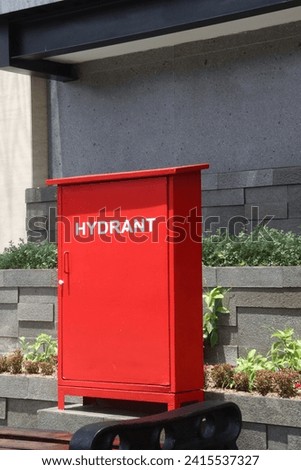A simple photo, functional hydrant with a rectangular red container serves as a clear marker for quick access to emergency water, emphasizing its crucial role in safety and environmental protection.