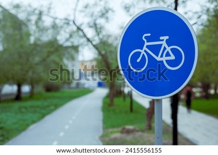 a blue road sign with a picture of a bicycle. the beginning of the track for cyclists