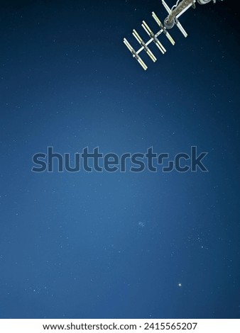 In a photo with a low shutter speed showing stars with a tv antenna frontground 