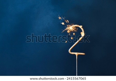 2 years celebration festive background made with Bengal fire in the form of number Two.  Royalty-Free Stock Photo #2415567065