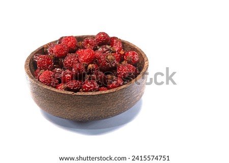 Isolated rosehip berries in a wooden bowl on a white background. Royalty-Free Stock Photo #2415574751