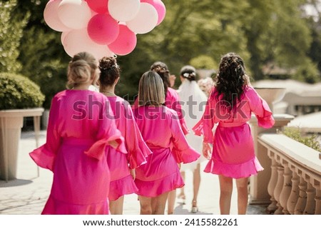 bridesmaids taking a walk in pink dressing gowns Royalty-Free Stock Photo #2415582261