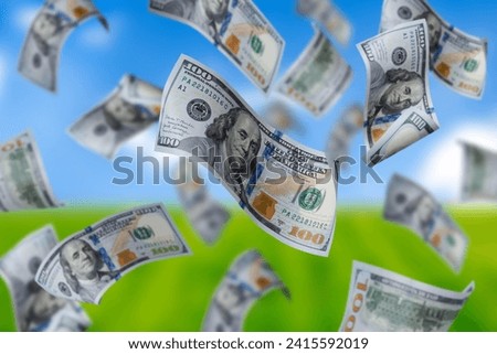 Flying dollars banknotes on the background blue sky and green grass. Money is flying in the air. 100 US banknotes new sample