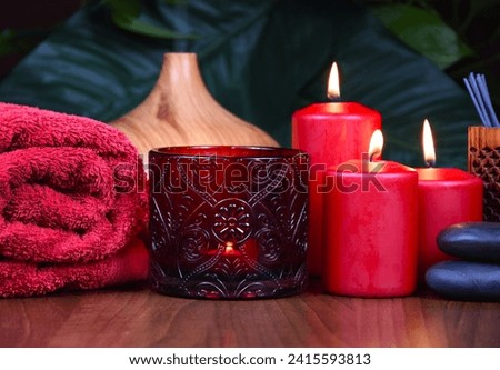 Spa still life with red candles, towel and massage stones on wooden background stock photo images. Spa wellness setting with red burning candles, towel and pebbles. Beauty spa treatment composition