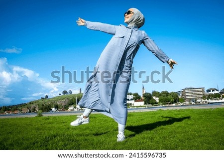 a Muslim woman joyfully raises her leg in a hijab. High quality photo