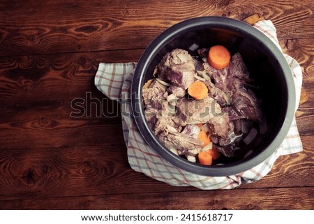 Beef, onion, carrot, garlic and spices in a metal pot before stewing. Slow cooking concept. Retro style photo, copy space