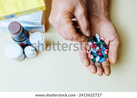 Unrecognizable close up handful of pills in his hand, other hand takes one piper from common pile. Prescribed treatment must be performed. Dependence on pills. Vitamins and minerals. Royalty-Free Stock Photo #2415632727
