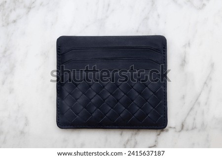 Dark leather, Credit card holder and money wallet, on marble floor and white background in the studio