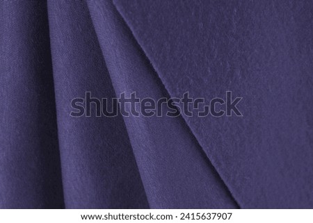 Layers of French terry lilac, dark purple, violet, charoite color fabric. Cut for sewing, footer warm textile, texture background. clothing creation, selection in a fabric store Royalty-Free Stock Photo #2415637907