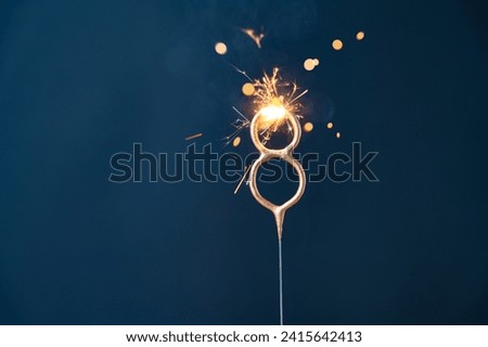8 years celebration festive background with copy space made with Bengal fire in the form of number Eight. Royalty-Free Stock Photo #2415642413