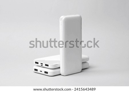 White power banks on a gray background. External battery Royalty-Free Stock Photo #2415643489