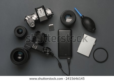 Minimalistic set of professional photographer equipment on a dark gray background. Modern mirrorless camera and accessories. Flat lay