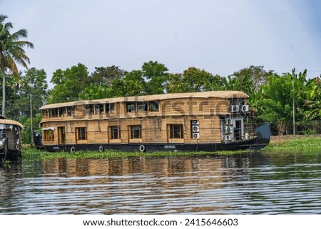 House boat in backwaters near palms in Alappuzha, Kerala, South India