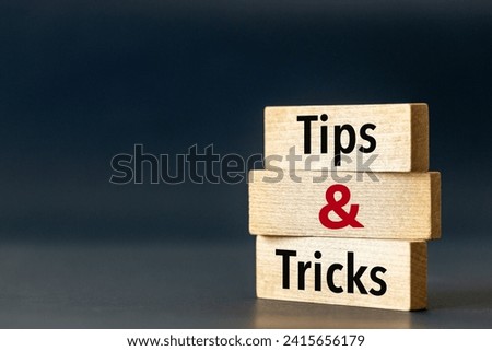 Wooden blocks with the words Tips and Tricks. Tips and tricks icon. Beautiful blue navy background. Business concept and business consulting. Copy space.