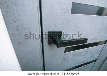 black handle on a gray ajar door close-up Royalty-Free Stock Photo #2415660495