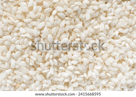 Uncooked organic white rice, background. Carbohydrate - food type  Royalty-Free Stock Photo #2415668595