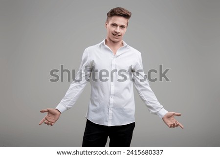 In a friendly gesture, the white-shirted man portrays both casual approachability and stylish dress sense Royalty-Free Stock Photo #2415680337