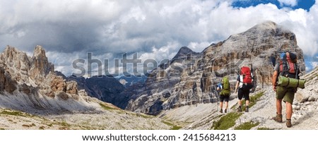 Valley Val Travenanzes and rock face in Tofane gruppe and group of hikers, Alps Dolomites mountains, Italy Royalty-Free Stock Photo #2415684213