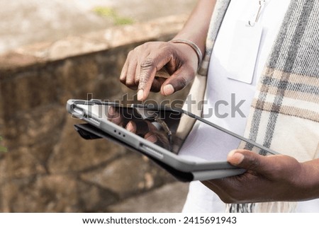 Man's Hand Holding Tablet in Outdoor Setting