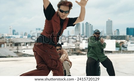 Group of professional hip hop dancer practice break dance on roof top. Skilled choreographer show freestyle movement while friend encourage, cheer,clap hands. Outdoor sport 2024. Endeavor.