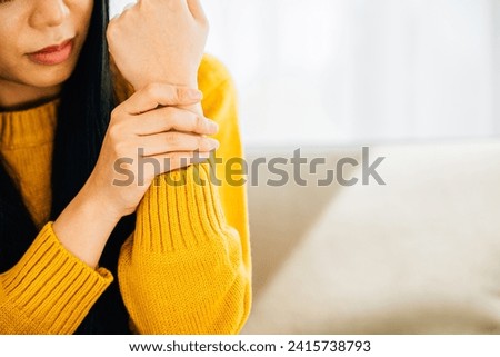 Illustrating hand pain, Woman holds her achy wrist indicating Carpal Tunnel Syndrome or discomfort. Emphasizing inflammation symptoms and discomfort in the hand's anatomy. Health care concept