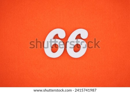 Orange felt is the background. The numbers 66 are made from white painted wood. Royalty-Free Stock Photo #2415741987