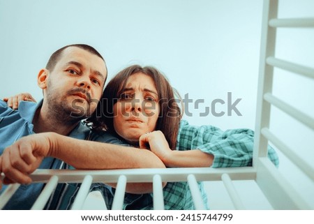 
Worried Parents Looking into the Crib Having Mixed Feelings
New mom and dad overthinking and feeling confused about parenting 
 Royalty-Free Stock Photo #2415744799