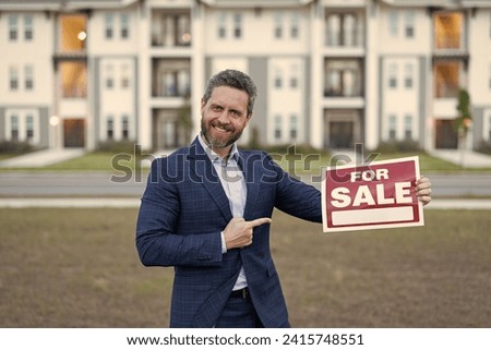 photo of broker with for sale board, point finger. sale property by broker. man broker