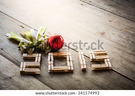 Clothes peg set in the 2015 and green bow, red Christmas ball on wooden background