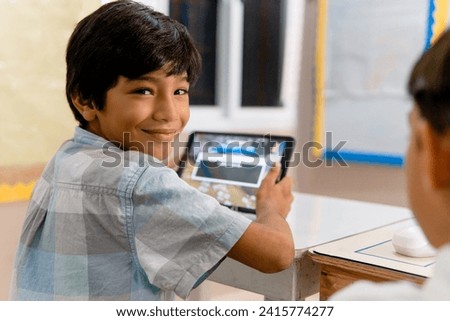 Portrait of Elementary Hispanic school Kids using tablet computers in class Royalty-Free Stock Photo #2415774277