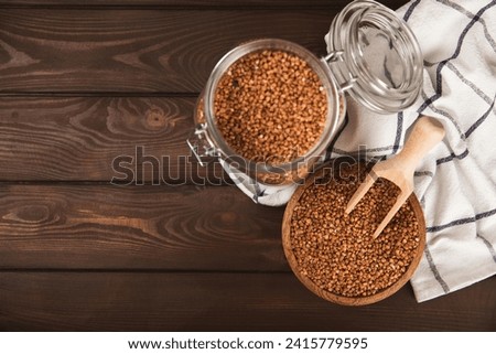 Raw buckwheat in a bowl on a textured background.Wheat grains, porridge, cereals, raw buckwheat in a plate. Healthy food. Porridge. Diet. Organic cerea. Space for text.Copy space.