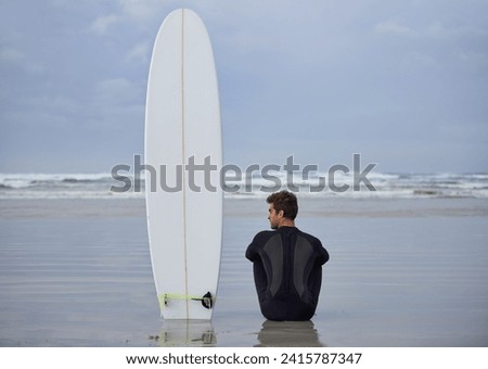 Beach, fitness and man thinking with a surfboard for wellness, sports and training while sitting in nature. Water, exercise and back of male surfer at the ocean with peace, calm and sea hobby in Bali Royalty-Free Stock Photo #2415787347