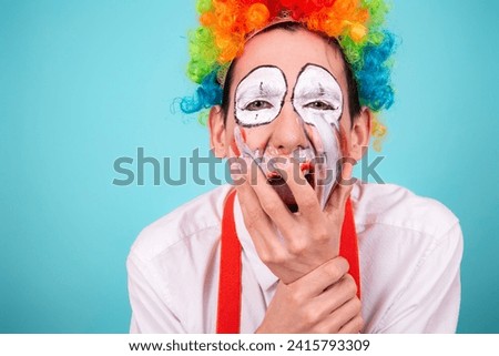 A screaming clown. Greased makeup. Blue background. A rude, angry, offended man.