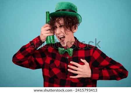 St.Patrick 's Day. A funny Irish holiday. Happy guy drinks green beer. Blue background.