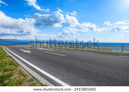 Asphalt road and blue lake nature landscape under blue sky
