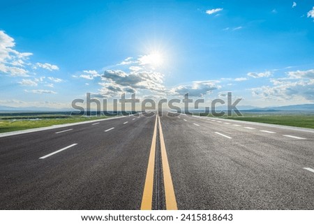 Straight asphalt highway and green grassland with sky clouds nature landscape in summer