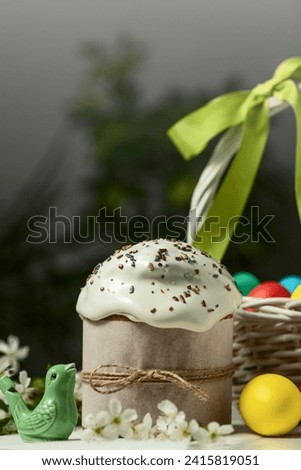 traditional Orthodox Easter cake and colored eggs in a wicker basket, on a white table in the middle plan. happy Easter