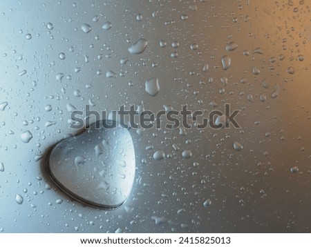 Heart-shaped lid on a silver background with water drops for Valentine's Day.