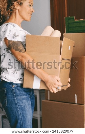 Modern female working at home with cardboard box for moving and renovating indoor leisure activity. Young female busy with boxes and packages. Mortgage and loan with people. Changing life concept lady