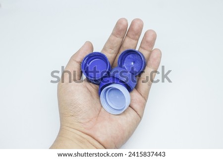 person holds color bottle caps, recycling plastic