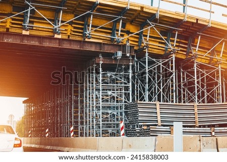 Construction of bridge. The road is currently under construction at several levels to increase traffic. Overpass road and support concrete structure with steel elements. Incomplete building site. Royalty-Free Stock Photo #2415838003